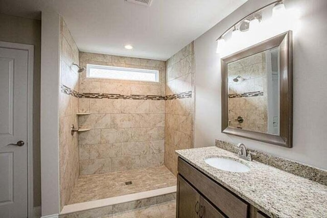 bathroom featuring vanity and tiled shower