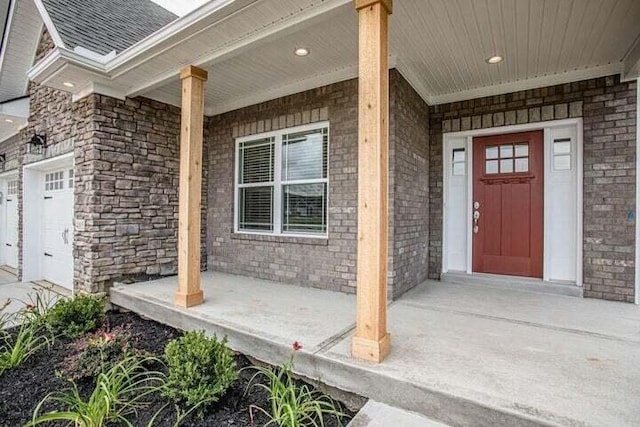 entrance to property with covered porch and a garage