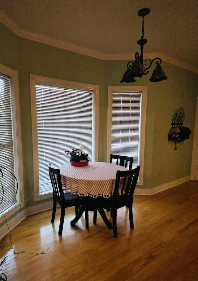 dining area with hardwood / wood-style floors and ornamental molding