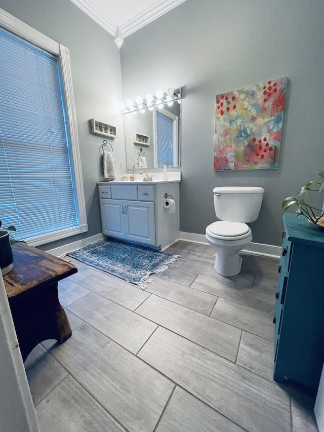 bathroom featuring hardwood / wood-style flooring, vanity, toilet, and crown molding