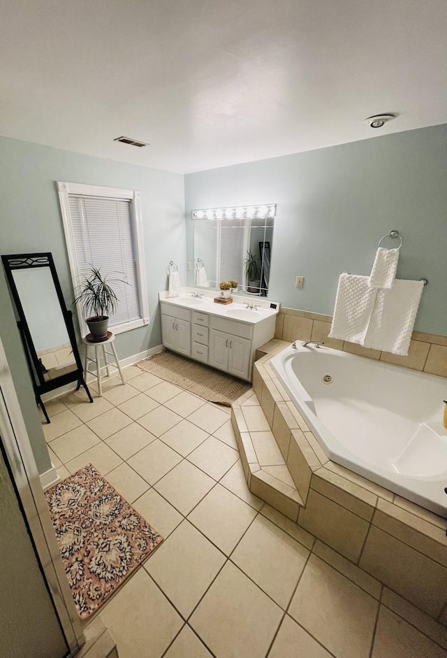 bathroom with tile patterned floors, vanity, and tiled bath