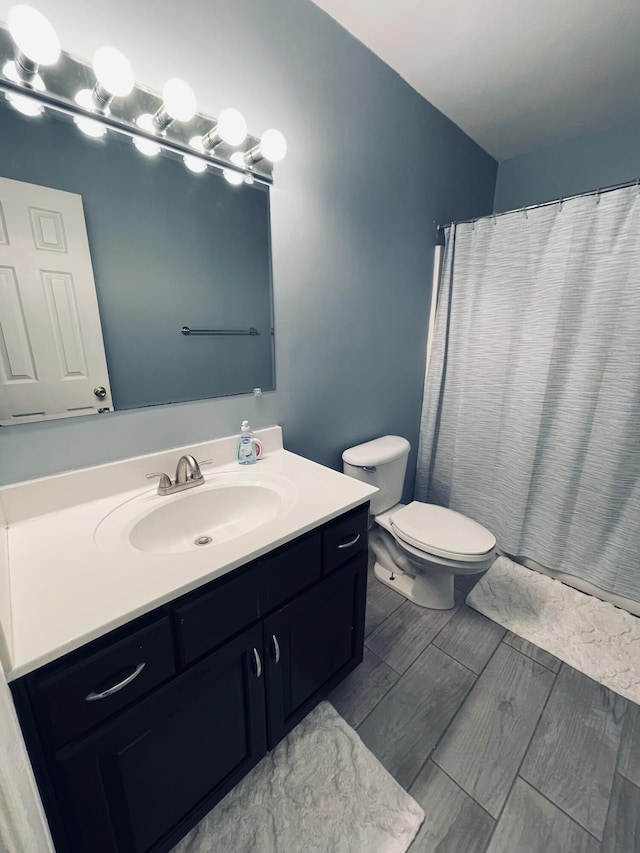 bathroom featuring vanity, toilet, and walk in shower