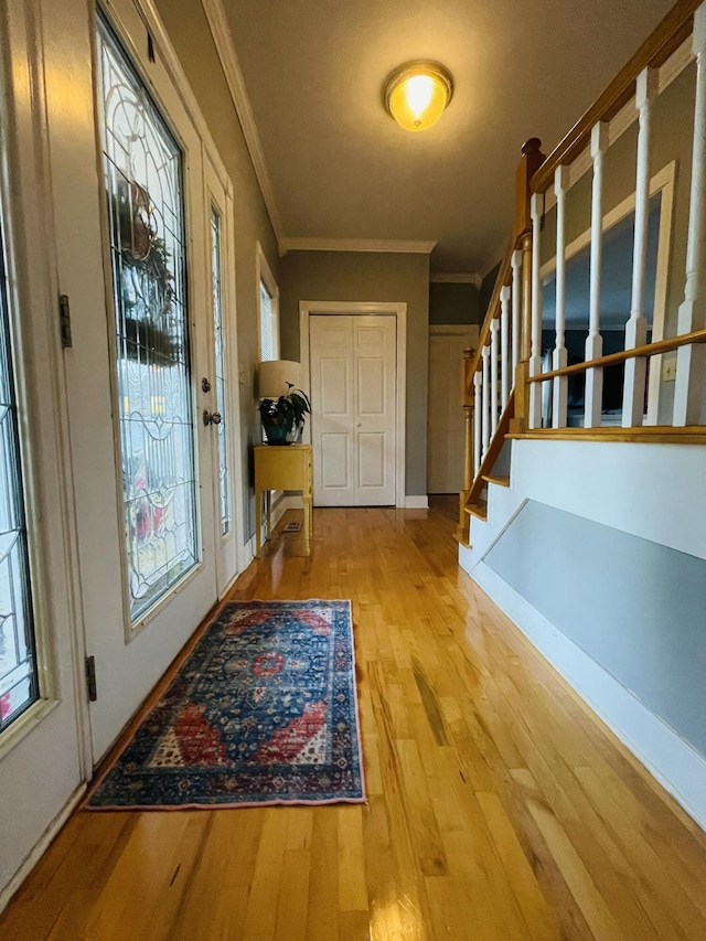 doorway to outside featuring light hardwood / wood-style flooring and ornamental molding