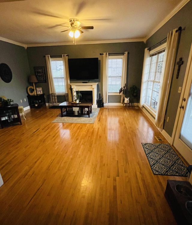 unfurnished living room with crown molding, ceiling fan, and hardwood / wood-style flooring