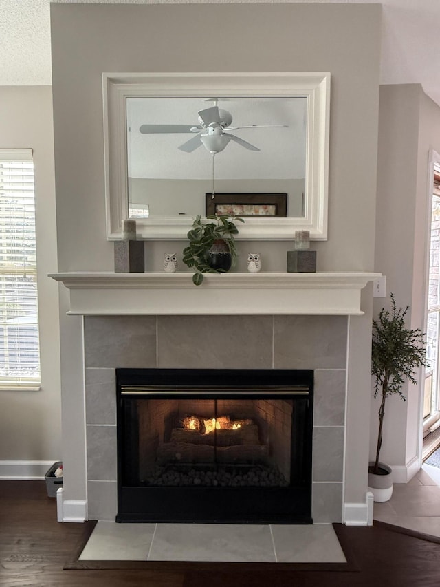 interior details with a tile fireplace, ceiling fan, a textured ceiling, and hardwood / wood-style flooring