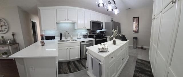 kitchen with white cabinets, decorative light fixtures, a center island, and stainless steel appliances