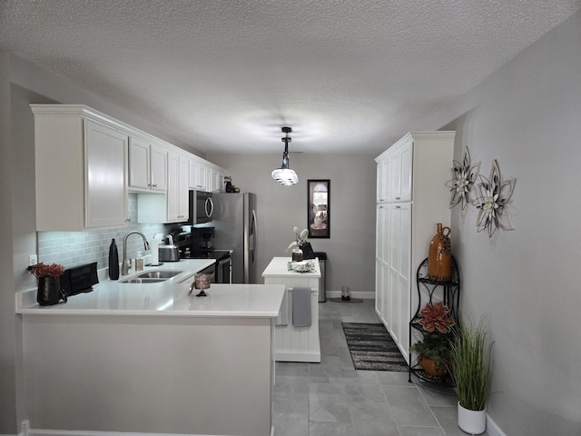 kitchen featuring kitchen peninsula, white cabinetry, sink, and appliances with stainless steel finishes