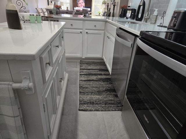 kitchen with white cabinets, backsplash, and stainless steel appliances