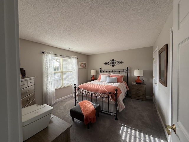 bedroom featuring dark colored carpet and a textured ceiling