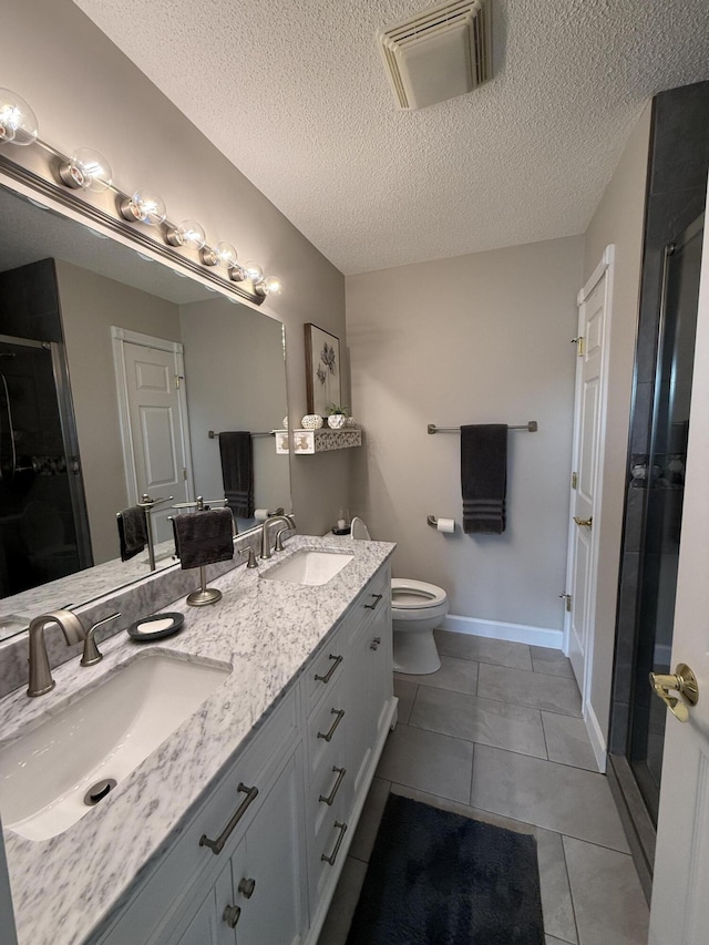 bathroom featuring vanity, tile patterned floors, toilet, a textured ceiling, and walk in shower