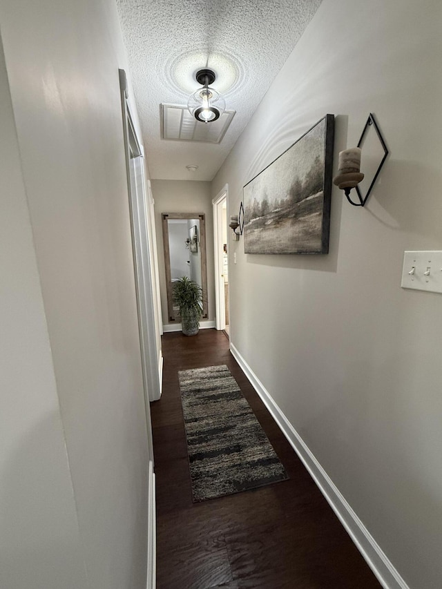 corridor featuring a textured ceiling and dark hardwood / wood-style floors