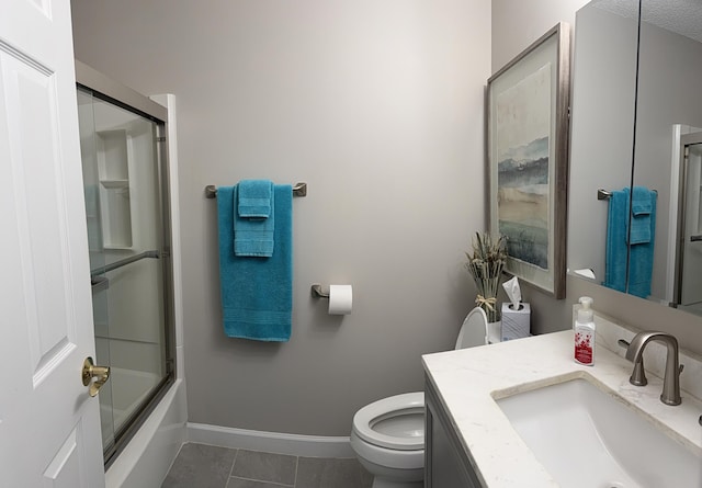 full bathroom featuring tile patterned flooring, vanity, bath / shower combo with glass door, and toilet