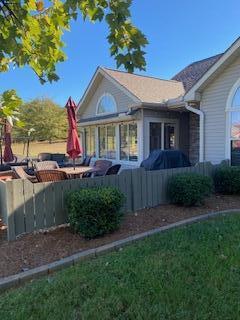 view of side of home featuring a sunroom and a yard