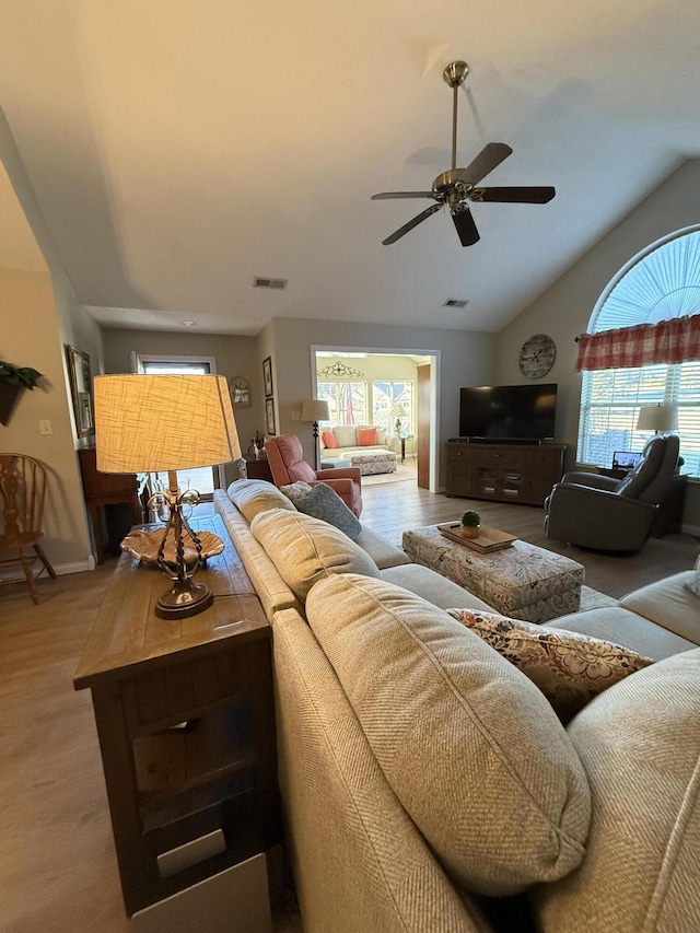 living room featuring ceiling fan, vaulted ceiling, and wood-type flooring