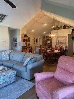 living room with ceiling fan and lofted ceiling