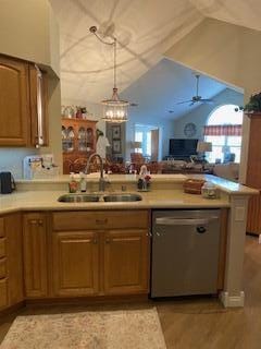 kitchen featuring sink, dishwasher, ceiling fan, vaulted ceiling, and kitchen peninsula