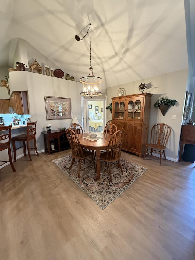 dining room with hardwood / wood-style flooring and lofted ceiling