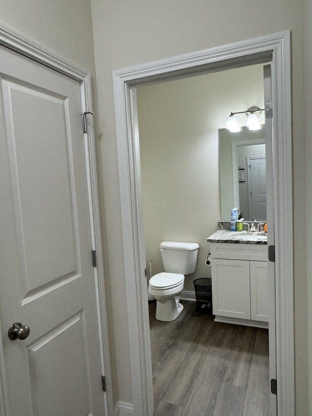 bathroom with vanity, wood-type flooring, and toilet