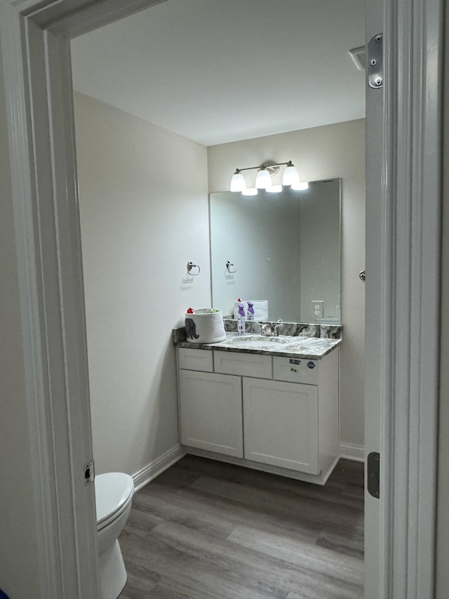 bathroom with vanity, wood-type flooring, and toilet