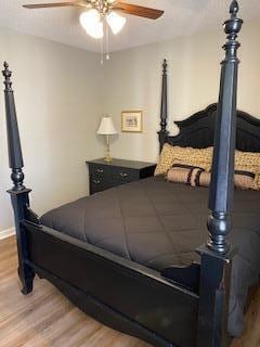 bedroom with ceiling fan and wood-type flooring