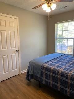 bedroom with hardwood / wood-style floors and ceiling fan