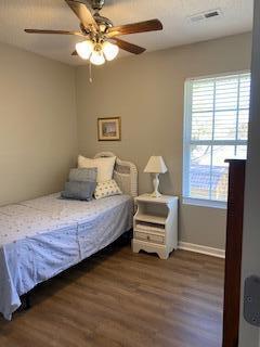 bedroom with ceiling fan and dark wood-type flooring