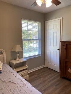 bedroom with ceiling fan, wood-type flooring, and a closet