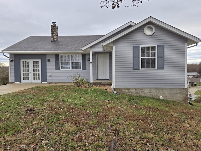 view of front of house with french doors and a front lawn