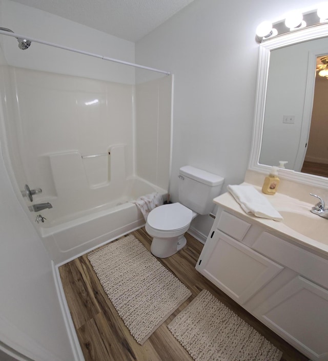 full bathroom featuring washtub / shower combination, toilet, wood-type flooring, and vanity