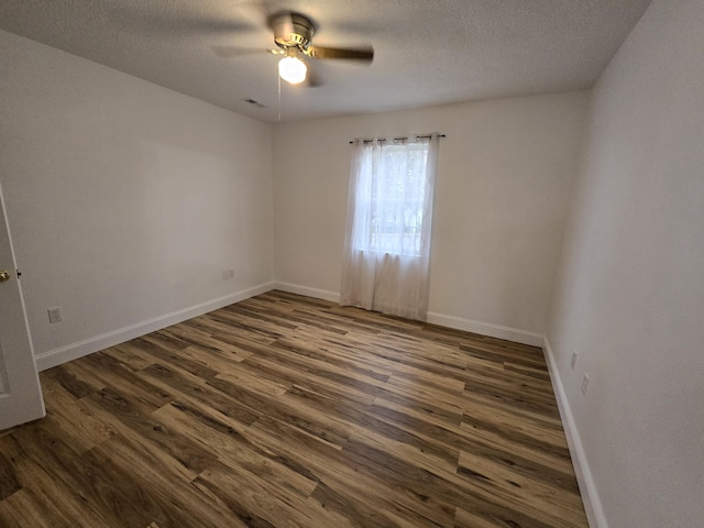 spare room with ceiling fan, dark wood-type flooring, and a textured ceiling