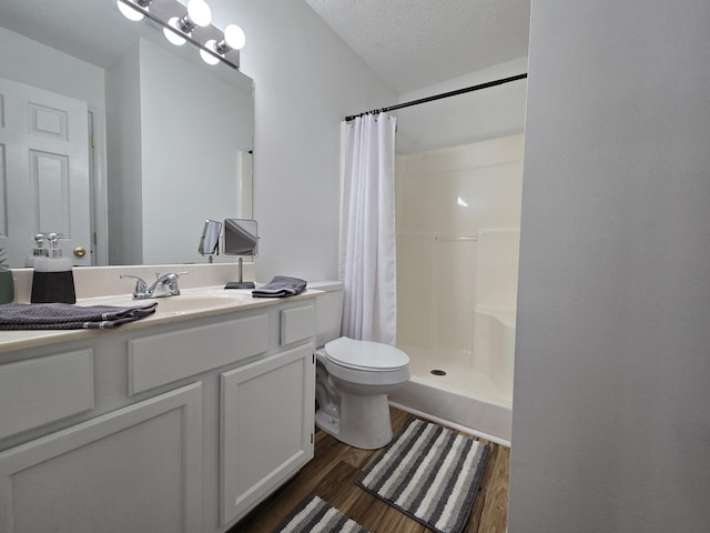 bathroom with hardwood / wood-style floors, vanity, a shower with shower curtain, toilet, and a textured ceiling