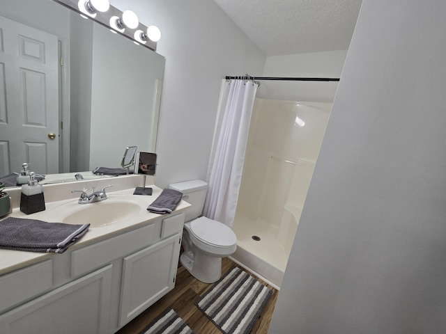 bathroom with curtained shower, hardwood / wood-style floors, a textured ceiling, toilet, and vanity