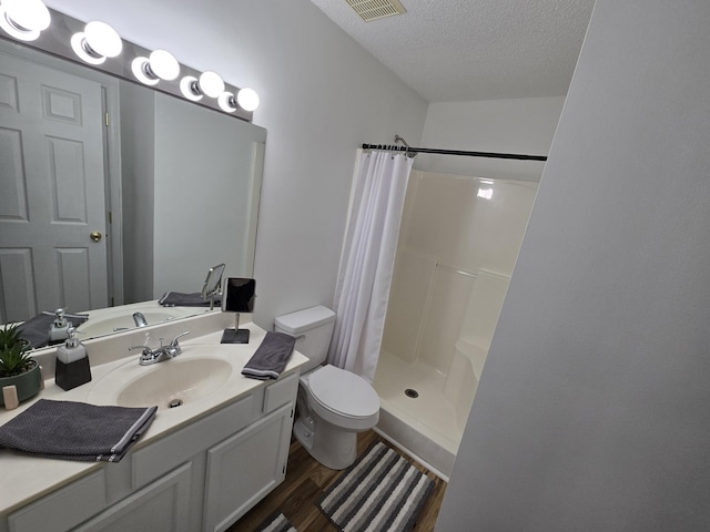 bathroom featuring walk in shower, vanity, a textured ceiling, wood-type flooring, and toilet