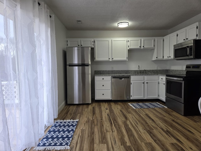 kitchen featuring sink, dark hardwood / wood-style flooring, white cabinetry, and stainless steel appliances