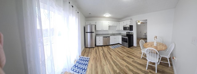 kitchen featuring white cabinets, a healthy amount of sunlight, stainless steel appliances, and light hardwood / wood-style flooring