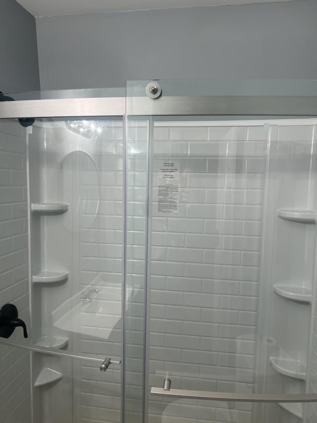 bathroom featuring a shower with door