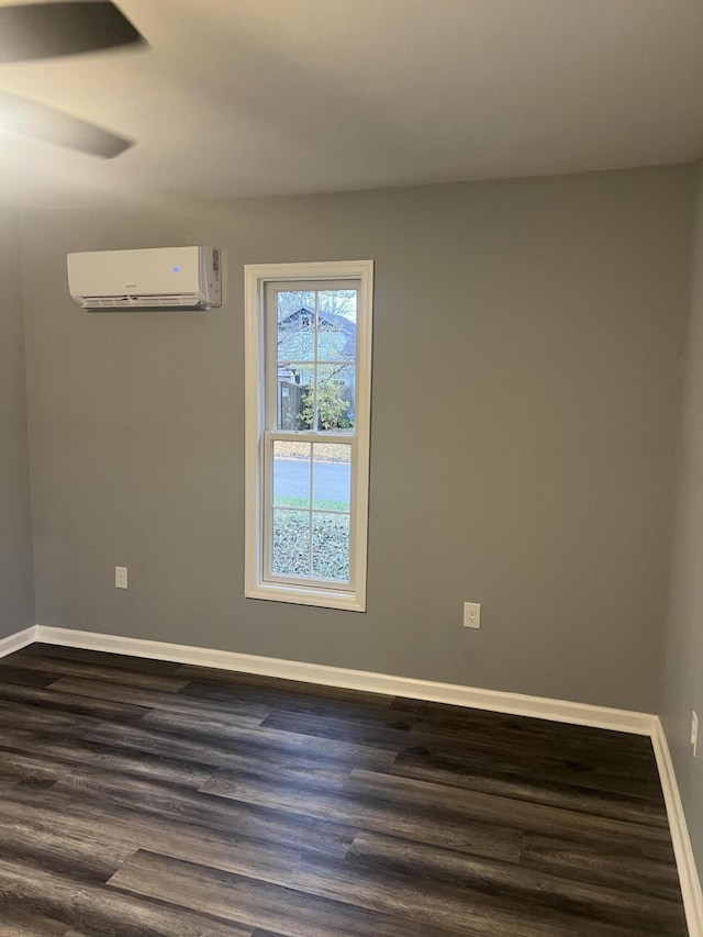 unfurnished room featuring ceiling fan, an AC wall unit, and dark wood-type flooring