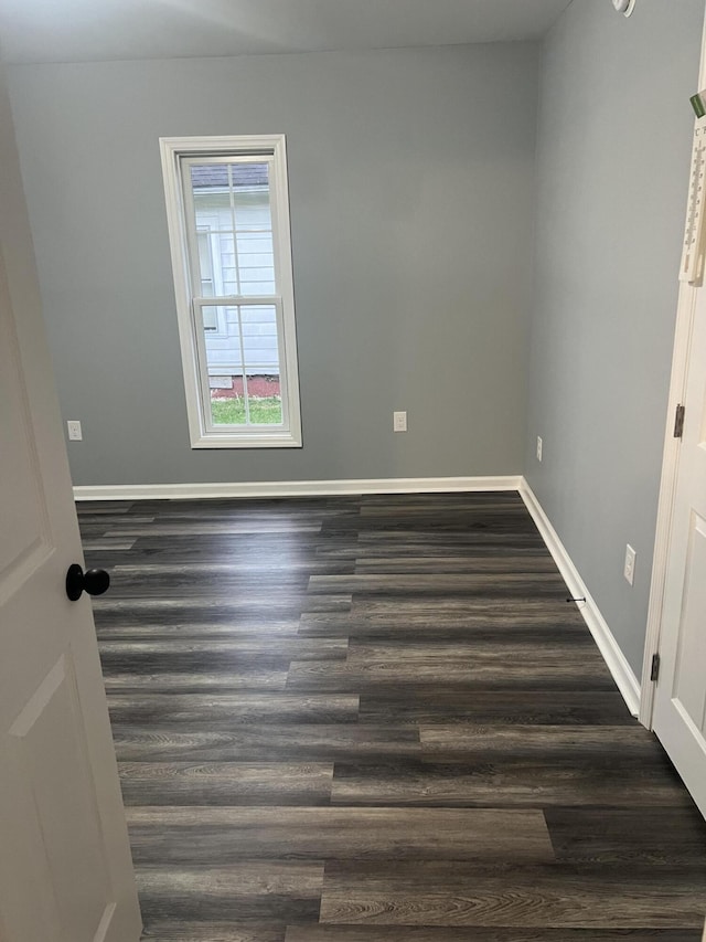 empty room with dark hardwood / wood-style flooring