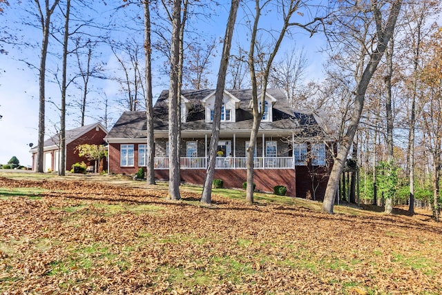 view of front of home with a porch and brick siding