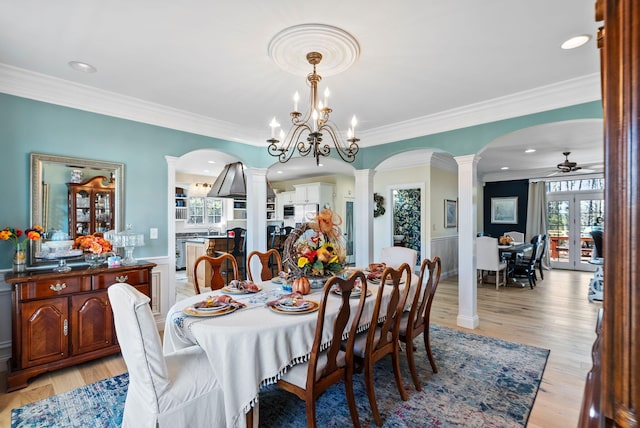 dining room with ceiling fan, light wood-style flooring, ornamental molding, and ornate columns