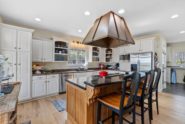 kitchen featuring open shelves, stainless steel appliances, a healthy amount of sunlight, and ventilation hood