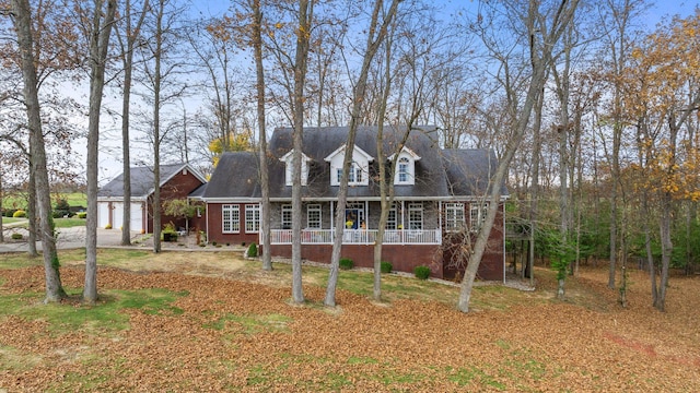 cape cod-style house with a porch and brick siding