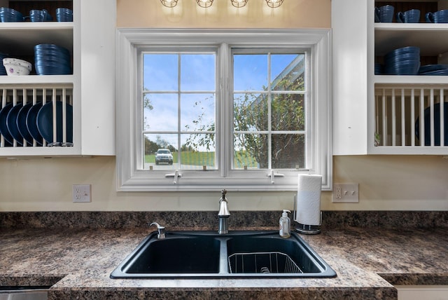 kitchen with a wealth of natural light, dark countertops, and a sink