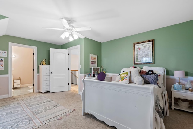 bedroom with ceiling fan, connected bathroom, and light carpet