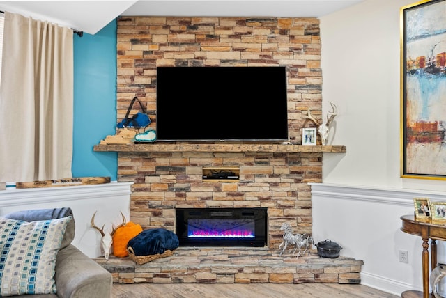 living area with a large fireplace and wood finished floors