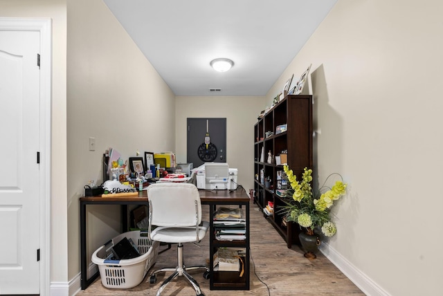 office with visible vents, baseboards, and wood finished floors