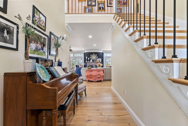 interior space featuring baseboards, ceiling fan, stairway, a fireplace, and wood-type flooring