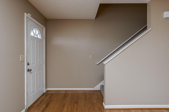 entryway featuring wood-type flooring and a textured ceiling