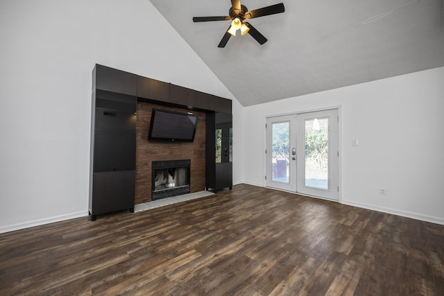 unfurnished living room featuring high vaulted ceiling, french doors, ceiling fan, a large fireplace, and dark hardwood / wood-style flooring