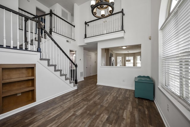 foyer featuring a high ceiling, dark hardwood / wood-style floors, and an inviting chandelier